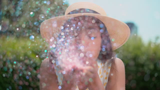 SLO MO Young Indian woman blowing glitter off her hands into the camera