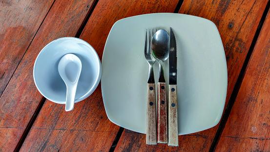 cutlery plate set. divided cups and short spoons on wooden table