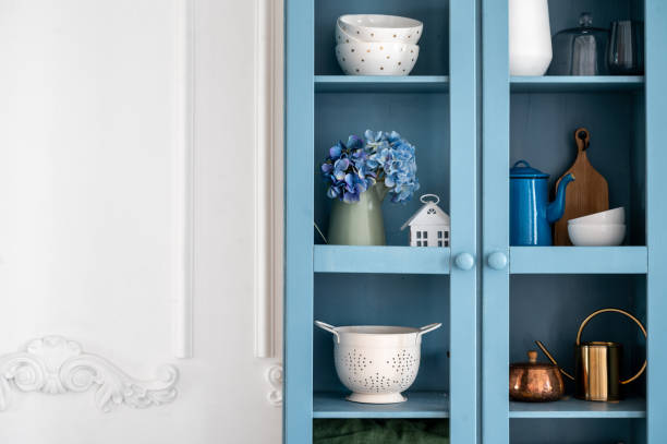 istock Blue vintage cupboard with kitchenware against white copy space wall 1635583660