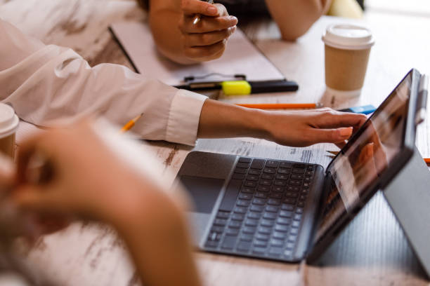 istock Close-up of female hands using a digital tablet in a modern office 1635590117