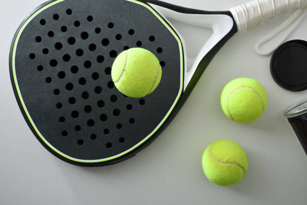 Black and white paddle tennis racket and ball pot top stock photo