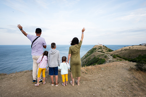 Happy family aboard. Mother in captain cap, little daughter on board of sailing yacht. Children have fun discovering islands in summer cruise. Travel adventure, yachting with kids on family vacation.