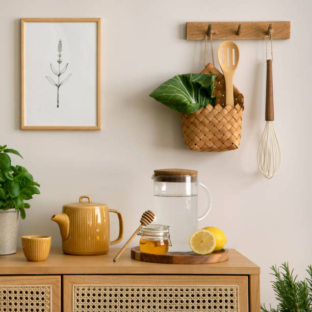 istock Creative composition of kitchen space with mock up poster frame, rattan commode, pitcher, herbs, vegetables, lemon, banana peach, food and kitchen accessories. Home decor. Template. 1635607047