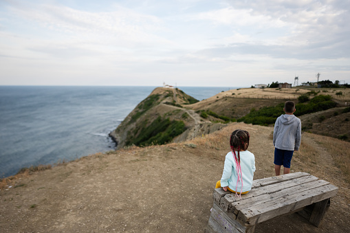 Little boy and girl looking at the sea from the top of a mountain. Cape Emine, Black sea coast, Bulgaria.