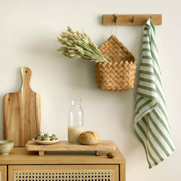 istock Interior design of kitchen space with rattan commode, cutting board, hanger, basket with dried herbs, vegetables, food, bread, milk and kitchen accessories. Home decor. Template. 1635607649
