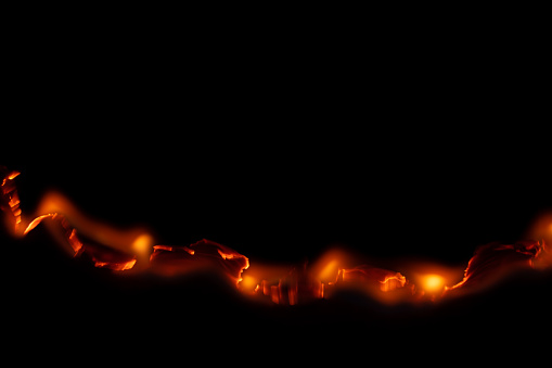 burning paper, glowing edge of paper on a black background