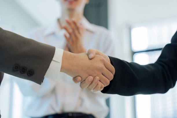 istock professional successful businesspeople in formal suit standing shaking hands greeting celebrating and colleagues clapping hands in company office 1635631115