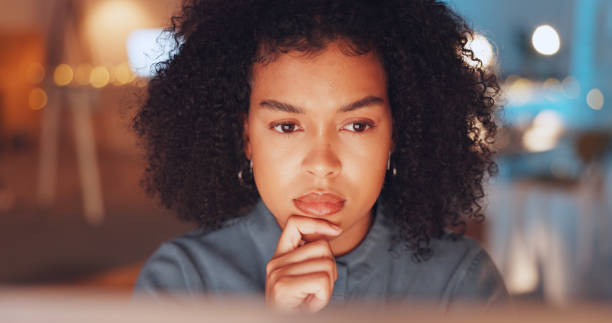 istock Night, thinking and computer with black woman in office for research proposal, project and satisfaction. Internet, technology and idea with employee in agency for information, confident or connection 1635650561