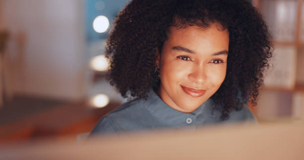 istock Night, happy and computer with black woman in office for research proposal, project and satisfaction. Internet, technology and idea with employee in agency for information, confident and connection 1635651075