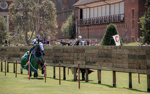 two  knights and  theirs  horses  charge  towards  each  other  on their  horses  in a  jousting  competition  and  royal  Tudor  joust  Hampton court   London