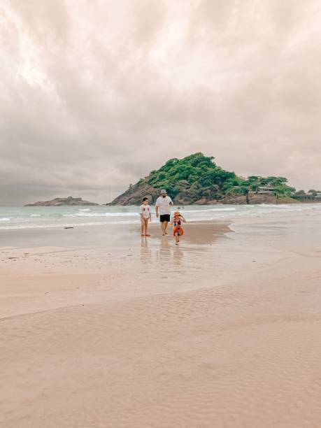 istock Affectionate father enjoying the sunny day at the beach, with his two children 1635653795