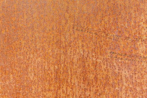Background of rusty weathering corten steel. Steel alloy with a stable rust-like appearance used in outdoor sculptures, architecture, gardening etc.