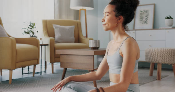 精神的なチャクラの平和、心の自由と禅の考え方に取り組んでいる黒人女性のための瞑想、ピラティスとホームヨガ。体の健康、ウェルネスライフスタイル、リビングルームの床でのリラッ� - yoga business women living room ストックフォトと画像