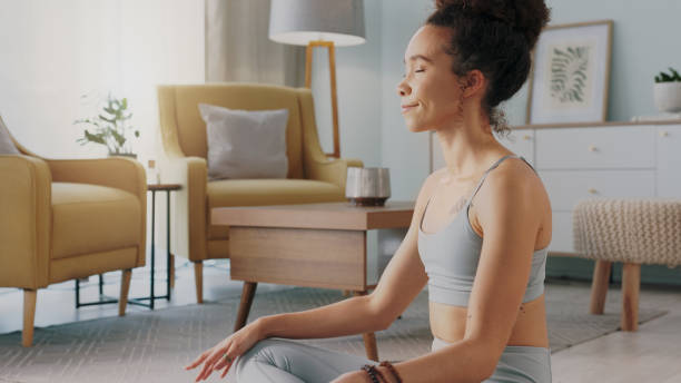 精神的なチャクラの平和、心の自由と禅の考え方に取り組んでいる黒人女性のための瞑想、ピラティスとホームヨガ。体の健康、ウェルネスライフスタイル、リビングルームの床でのリラッ� - yoga business women living room ストックフォトと画像