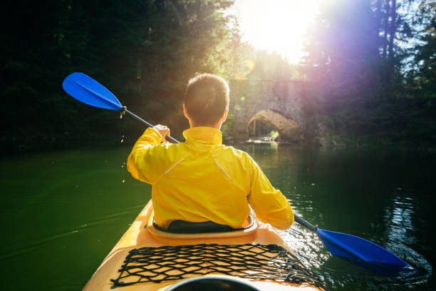 Mid adul man kayaking in a peaceful still water in a mountain lake.