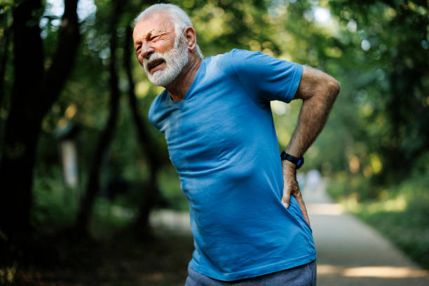 istock Sporty senior man having back pain while jogging 1635699442