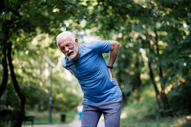 istock Sporty senior man having back pain while jogging 1635700013