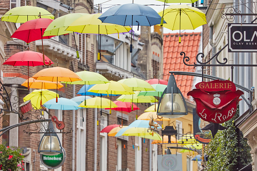 Deventer, The Netherlands - August 10, 2023: Colorful shopping street with umbrella decoration in the ancient city center of Deventer, The Netherlands