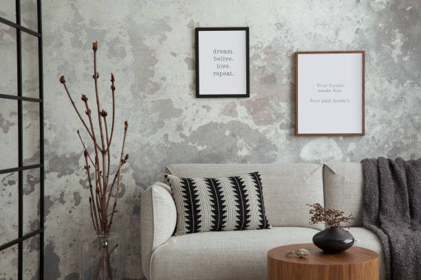 istock The stylish compostion at living room interior with mock up poster frame, design gray sofa, coffee table, plant, hanger, lamp and elegant personal accessories. Loft and industrial interior. Template 1635733206