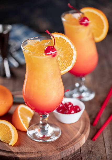 Tequila sunrise cocktail with cherry and orange slice Tequila sunrise cocktail with cherry and orange slice on rustic wooden table maraschino cherry stock pictures, royalty-free photos & images