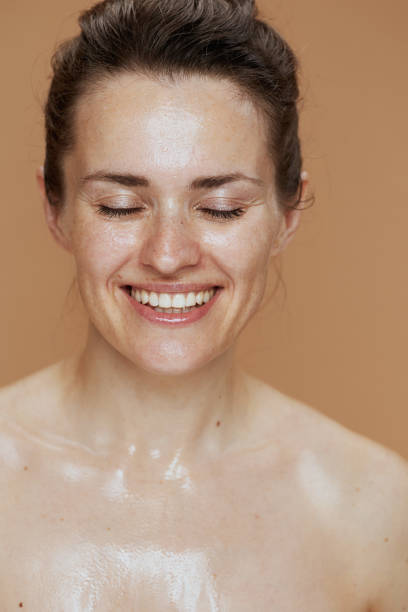 istock smiling young woman with wet face washing 1635745670