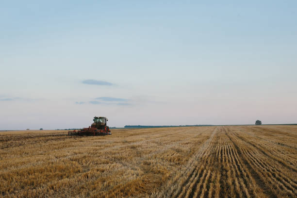 istock Modern tractor with a heavy trailed disc harrow works a wide hilly field. Autumn or spring agricultural campaign 1635746266