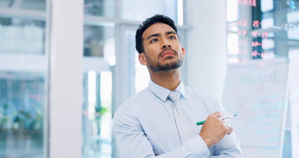 istock Thinking, strategy and serious businessman writing on glass wall with thoughtful analysis in office. Brainstorming, planning and vision of corporate worker with focus, concentration and idea. 1635786121