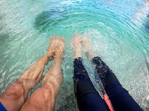 An Asian man and woman are relaxing by the swimming pool