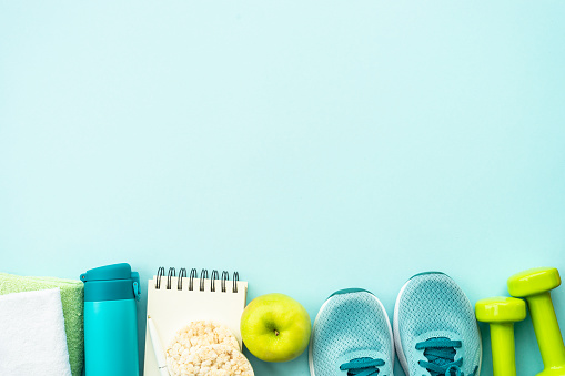 Fitness, workout, healthy lifestyle and clean eating concept. Top view on blue background.