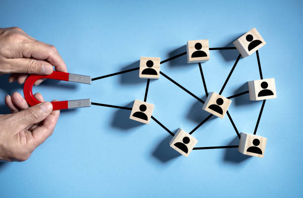 Magnet attracting clients, customers or employees from network and social media linked together stock photo
