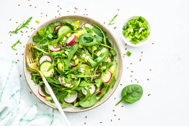 istock Green salad with spinach, arugula and radish with olive oil. 1635806772