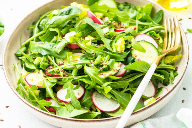 istock Green salad with spinach, arugula and radish with olive oil. 1635806776