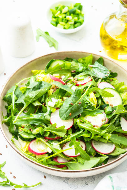 istock Green salad with spinach, arugula and radish with olive oil. 1635806790