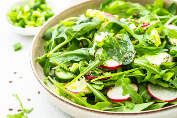 istock Green salad with spinach, arugula and radish with olive oil. 1635806794