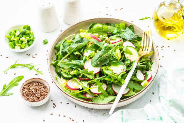 Green salad with spinach, arugula and radish with olive oil.
