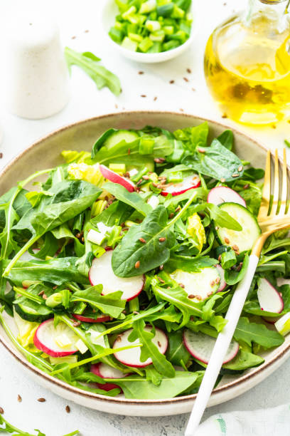 istock Green salad with spinach, arugula and radish with olive oil. 1635807330