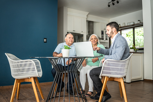 Financial advisor having a meeting with senior couple at home