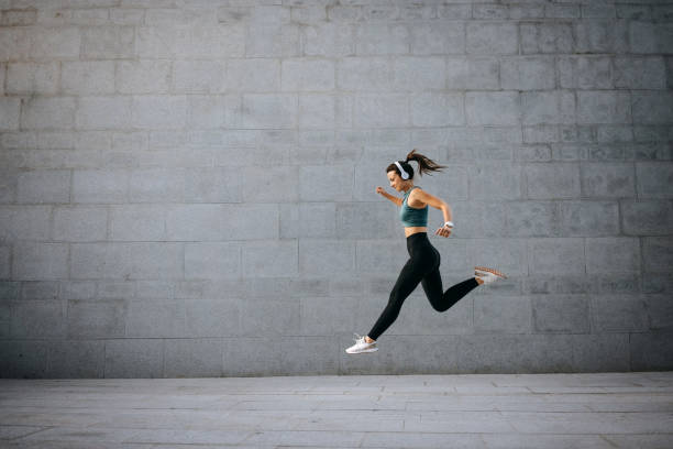 istock Fit young woman jumping and running 1635824035