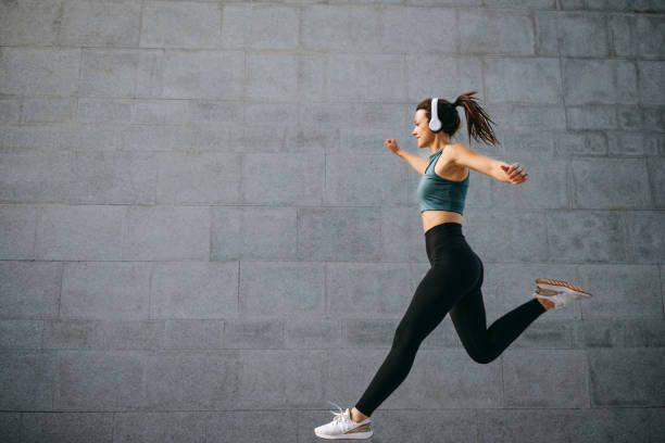 istock Fit young woman jumping and running 1635824042