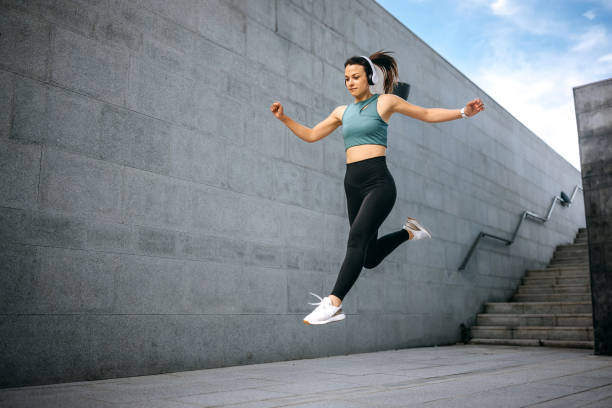 istock Fit young woman jumping and running 1635824050