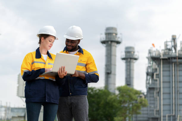 istock Engineer worker team in safety uniforms using laptop and deeply engaged in harnessing technology to analyze power generator data. Collective efforts aim to propel the plant's efficiency. The essence of teamwork and the power of Communication. 1635825765