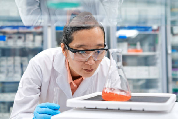 istock Female scientist weighing chemical in beaker while working at laboratory 1635830217