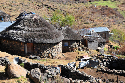 Lesotho highlands: circular thatched roof stone huts - rondavel huts, locally known as a 'mokhoro' - Basotho traditional village houses.