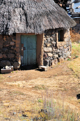 Lesotho highlands: circular thatched roof stone hut - rondavel hut, locally known as a mokhoro - village house.