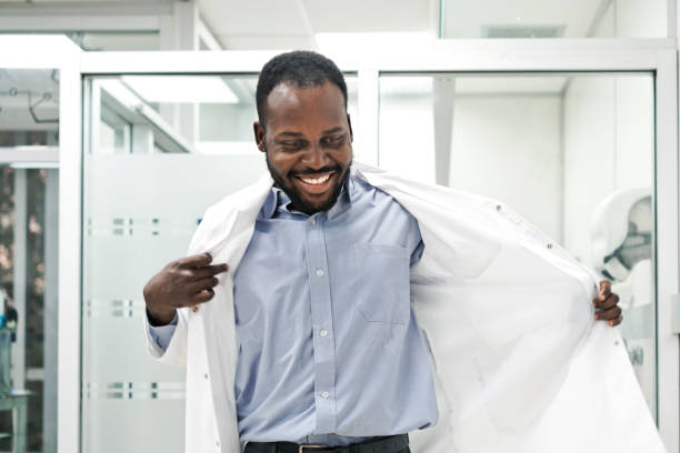 Smiling male medical worker wearing lab coat while standing in laboratory