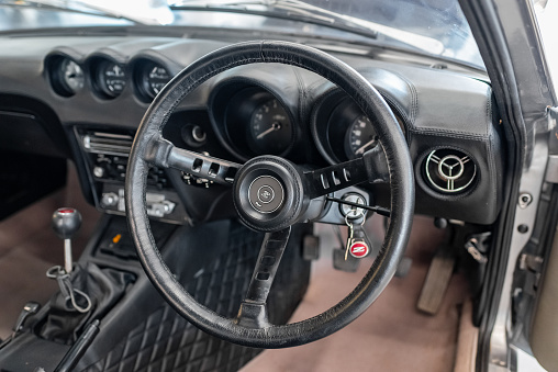 Vilnius, Lithuania - April 11, 2023: A rare JDM Datsun Fairlady Z parked in a private showroom, surrounded by other vintage cars in collection. Car after full restoration, painted in elegant grey colour. Interior view, fully reupholstered.