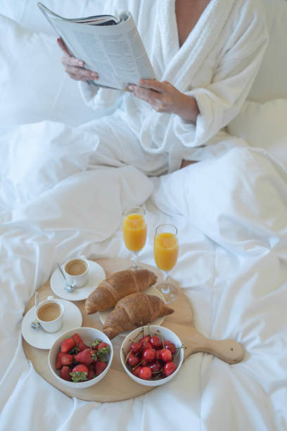 istock Young woman enjoys breakfast in bed 1635886036