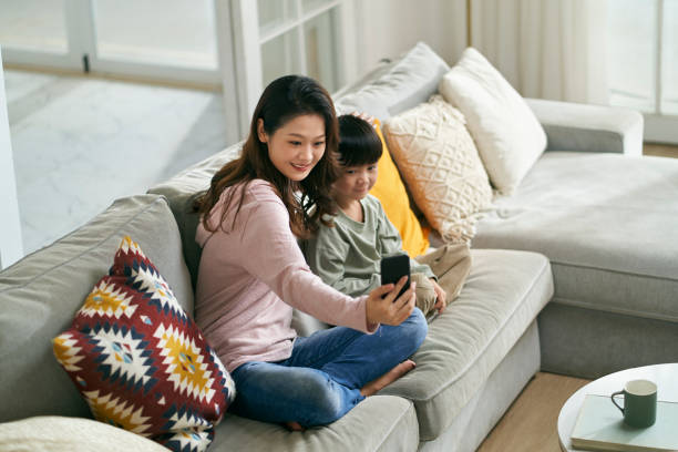 istock asian mother and son taking a selfie together at home using cellphone 1635911677