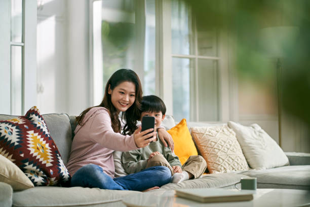 istock asian mother and son taking a selfie together at home using cellphone 1635912268