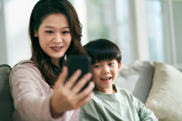 istock asian mother and son taking a selfie together at home using cellphone 1635912272